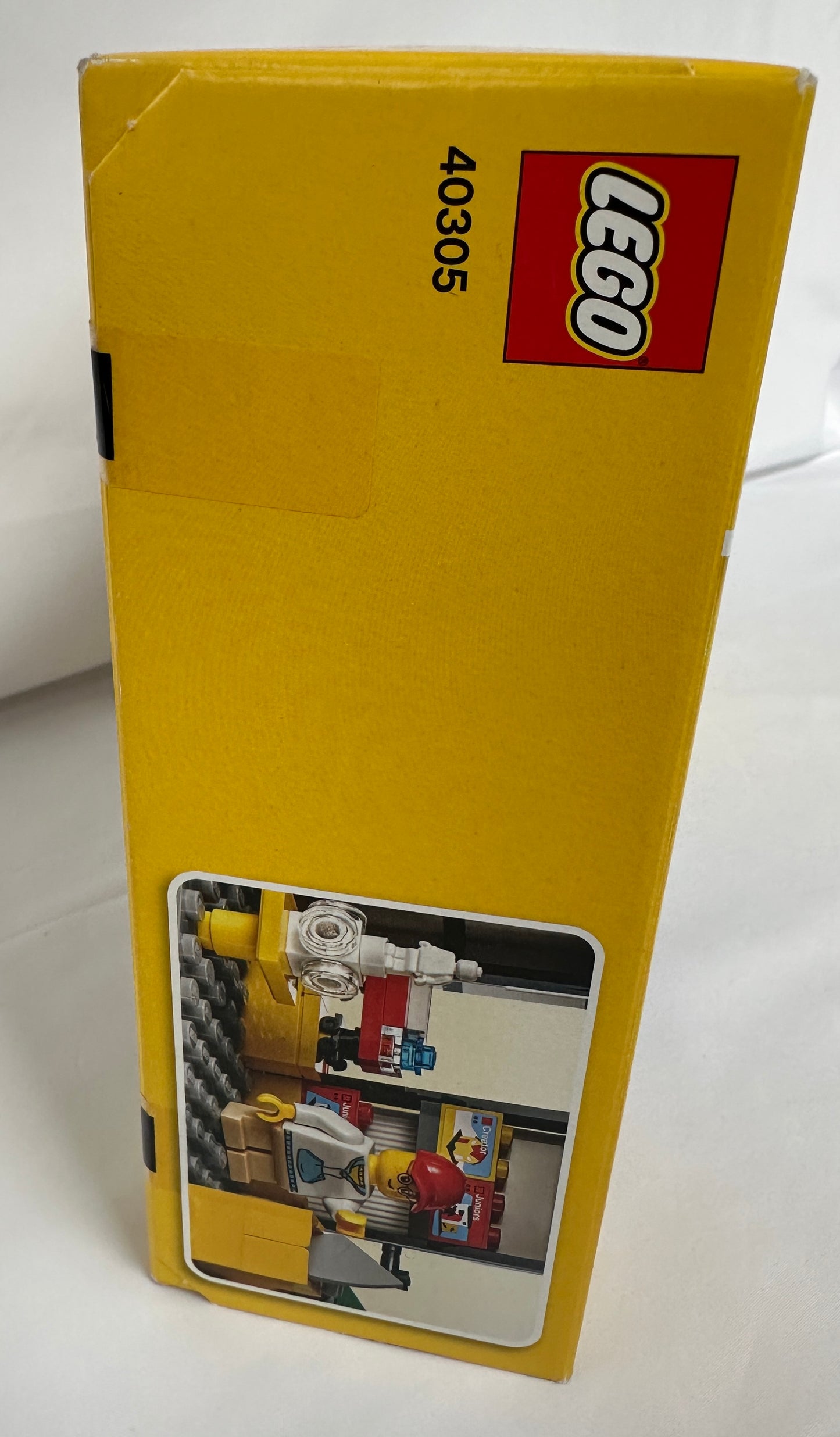 Yellow LEGO box with a small window showing a model, on a white background