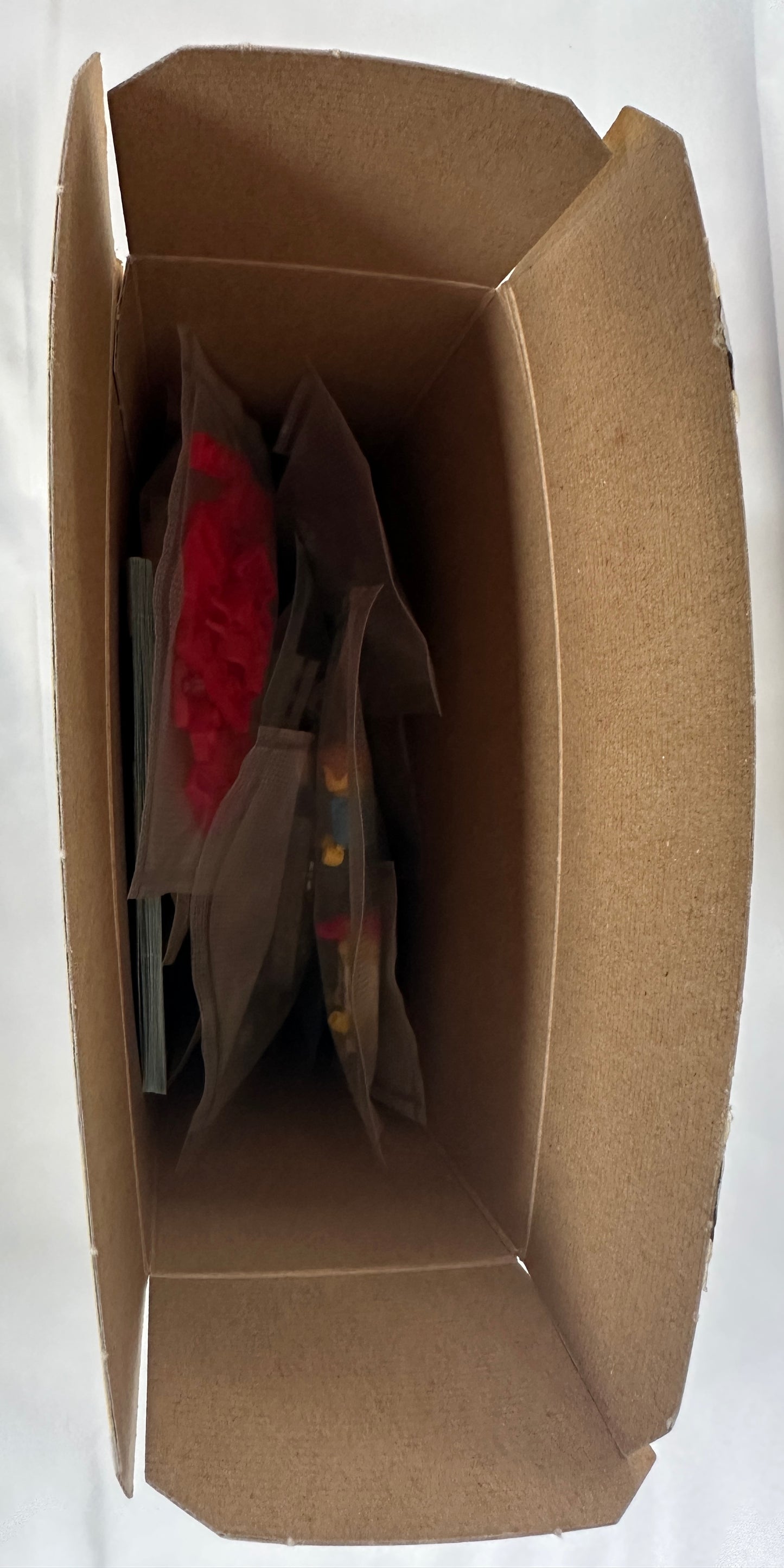 Brown cardboard box with bags inside on a white background