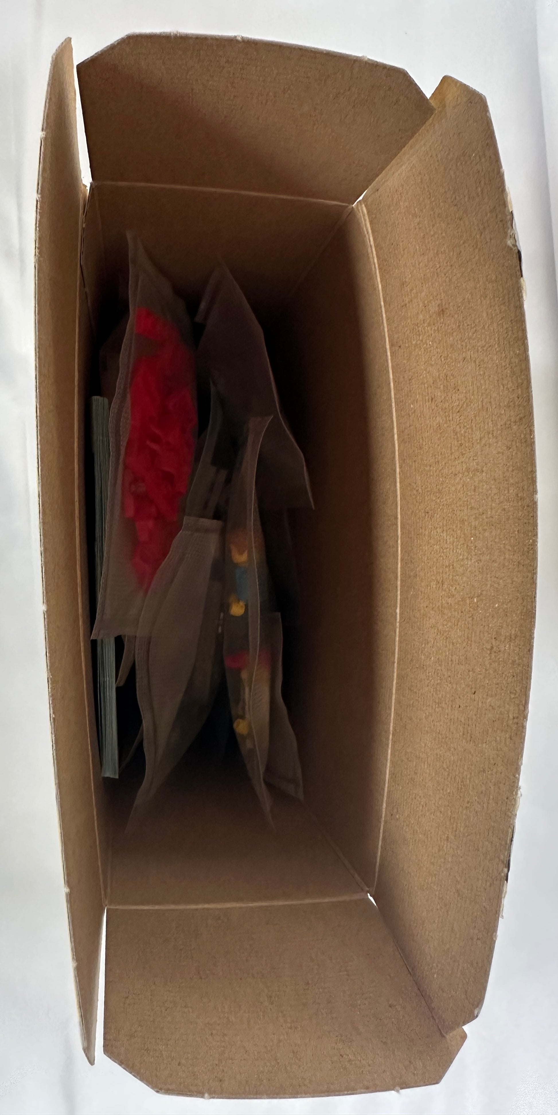 Brown cardboard box with bags inside on a white background
