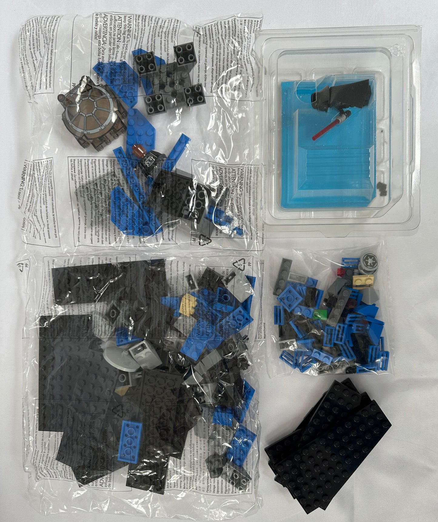 Open toy building block set with pieces and instructions on a white background