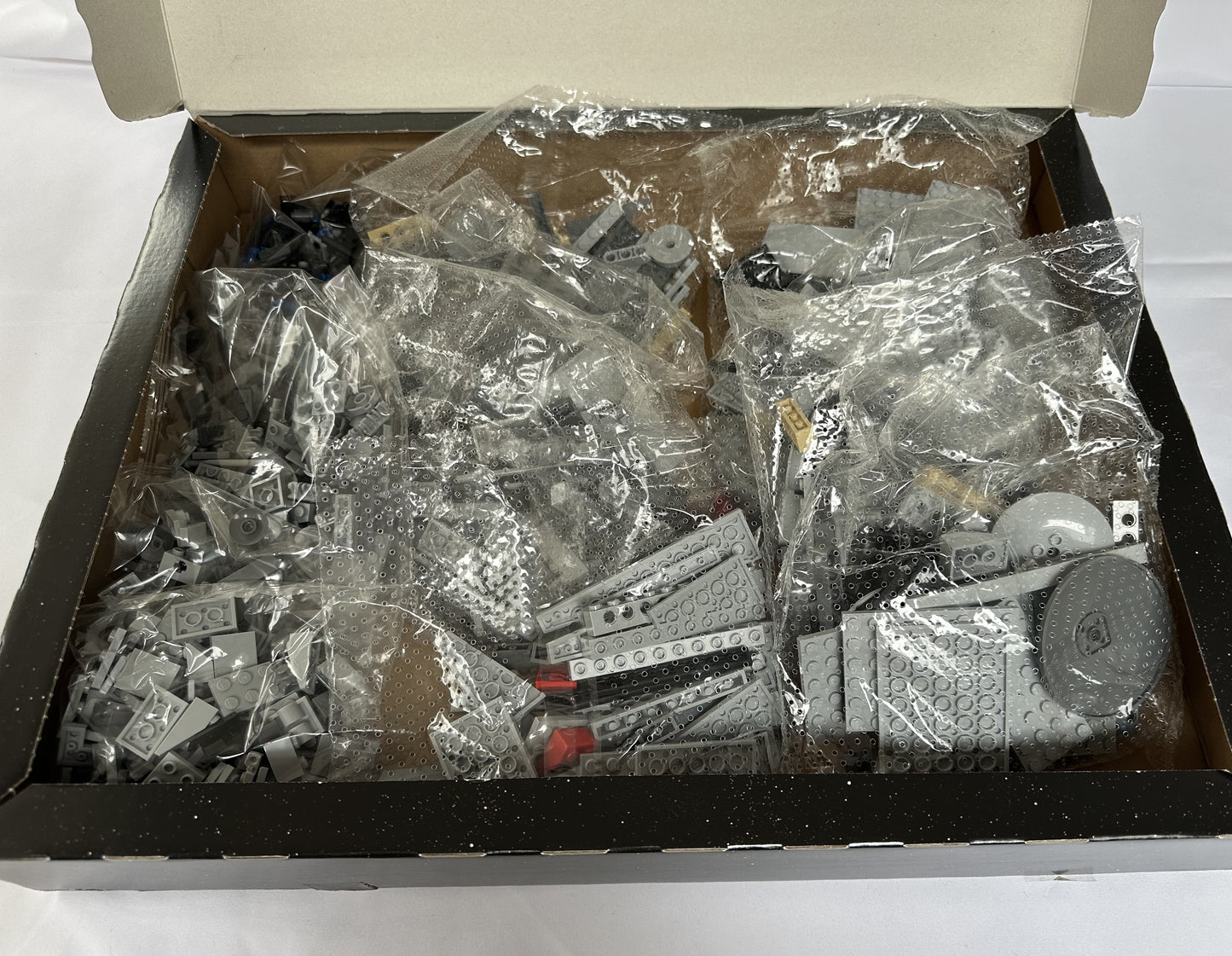 Box of assorted building blocks still in clear plastic packaging.
