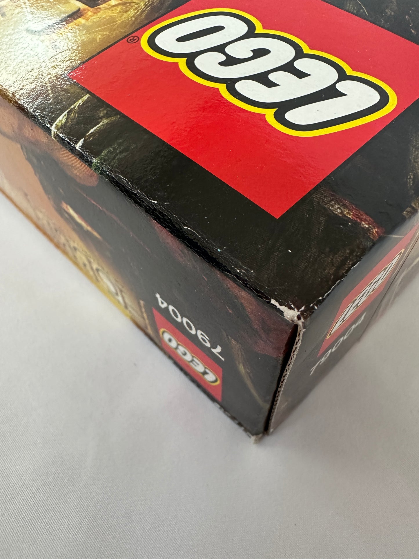 Close-up of a LEGO box with a red and black design on a gray surface