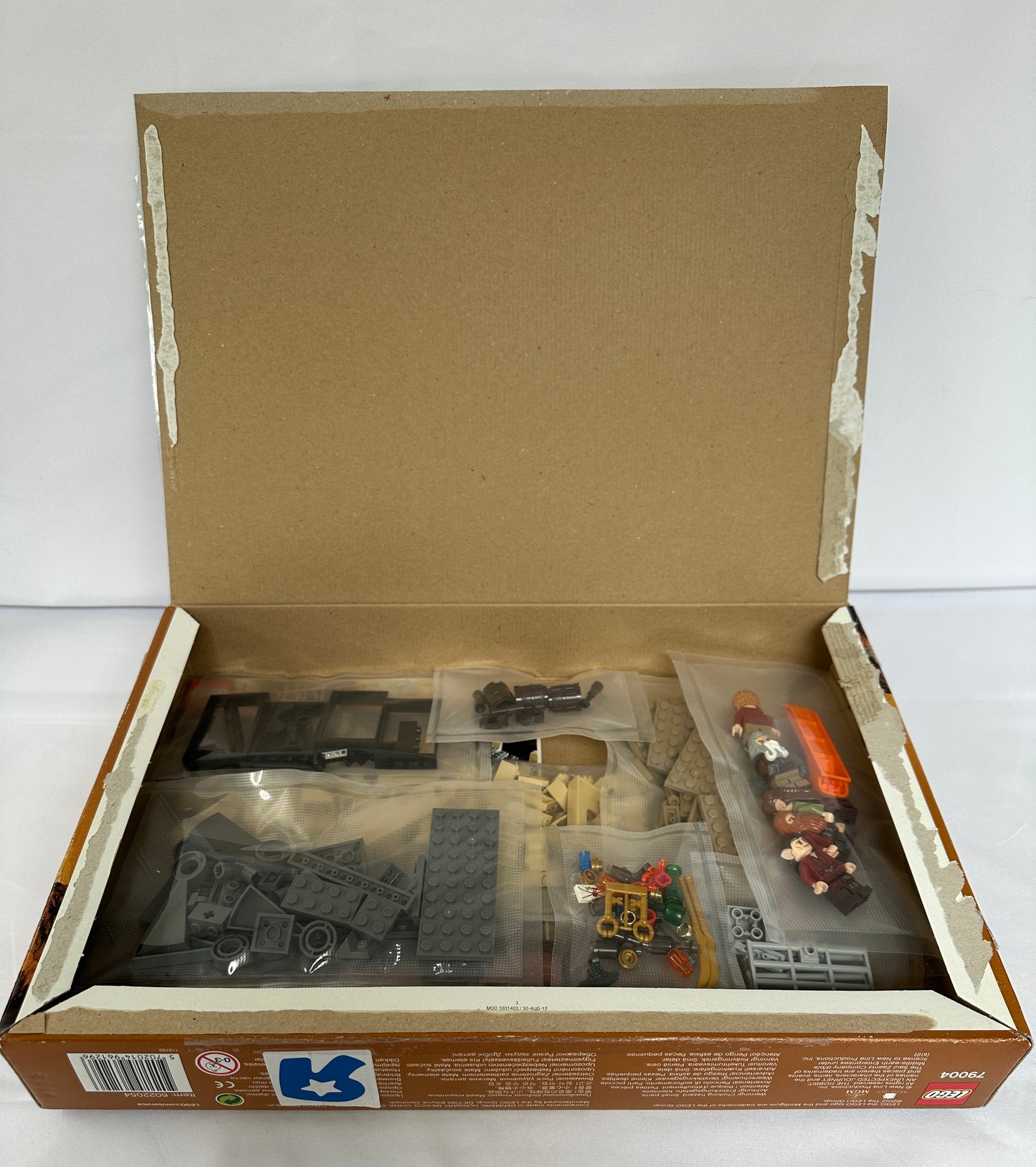Open cardboard box containing model building parts on a white background