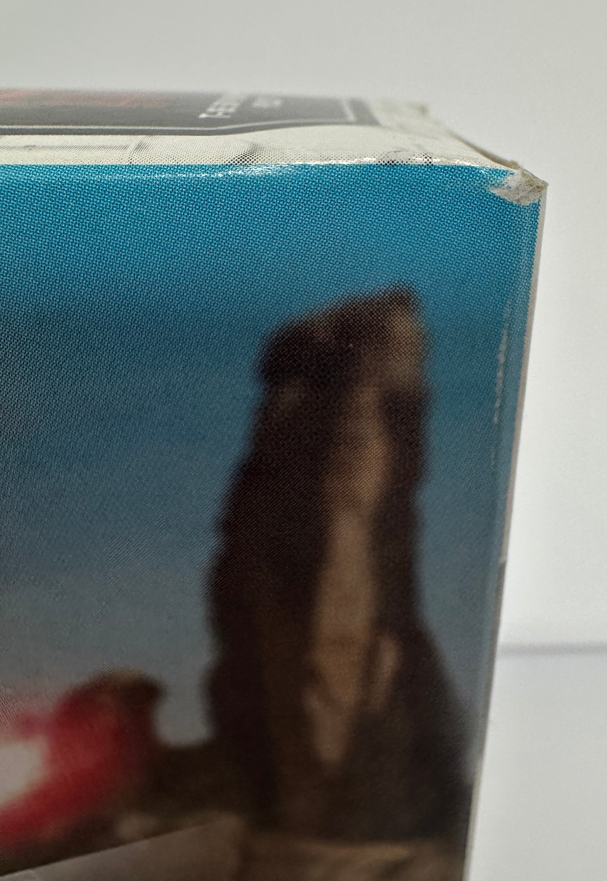 Close-up of a box with a blue cover and visible text, on a white background