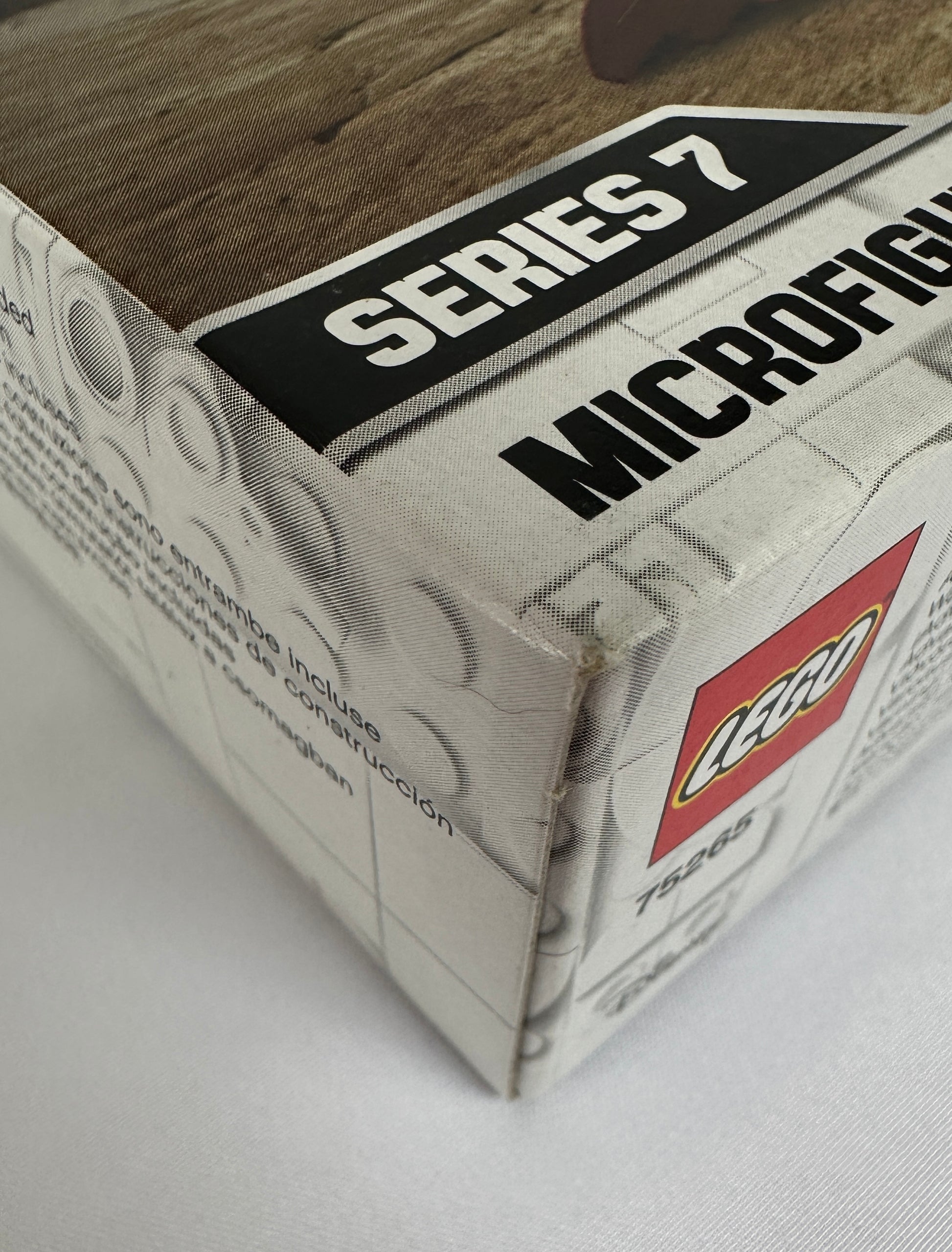 Close-up of a LEGO box labeled 'Series 7 Microfigs' on a wooden surface.