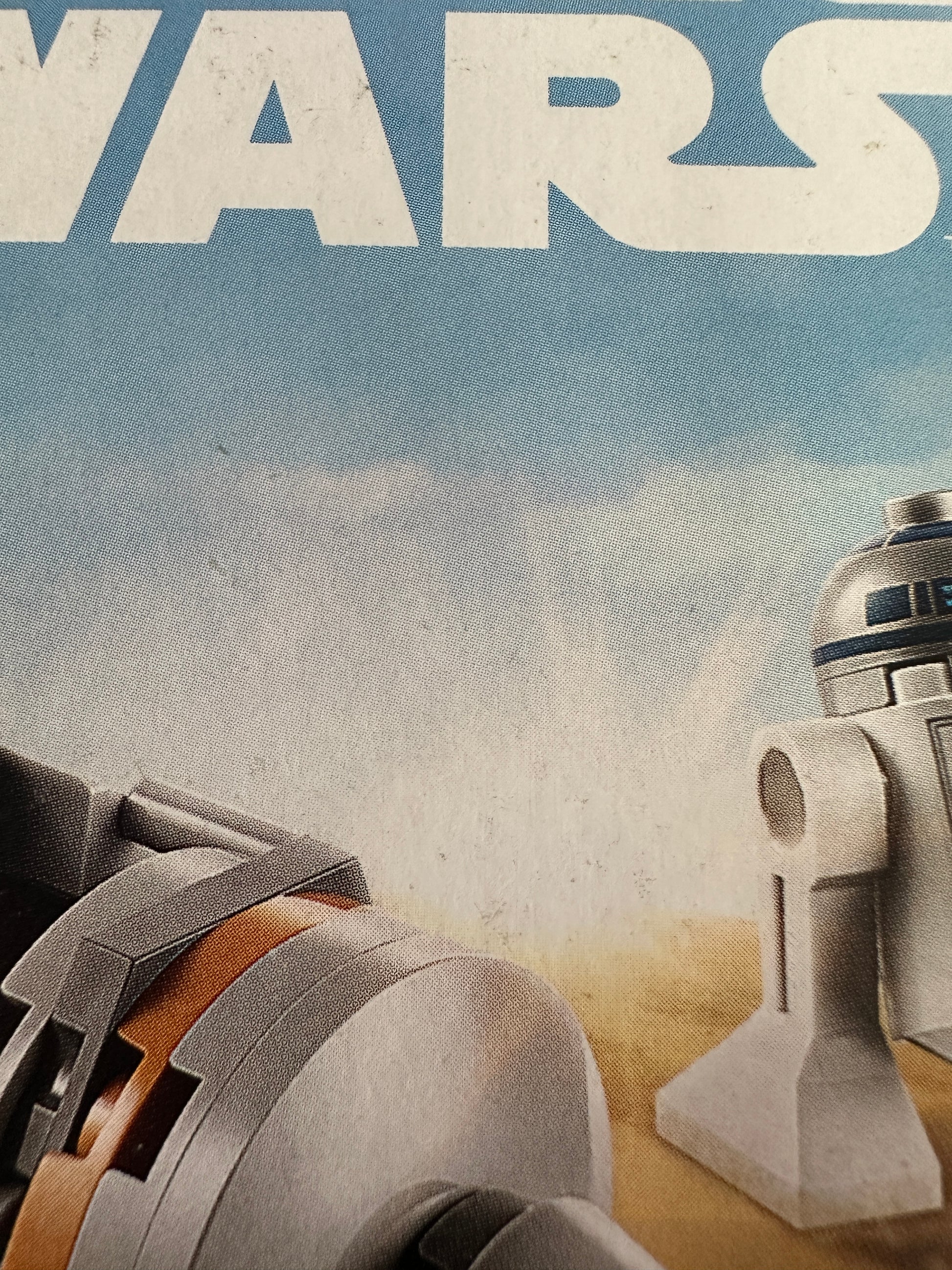 Close-up of a droid with 'Star Wars' branding on a textured background