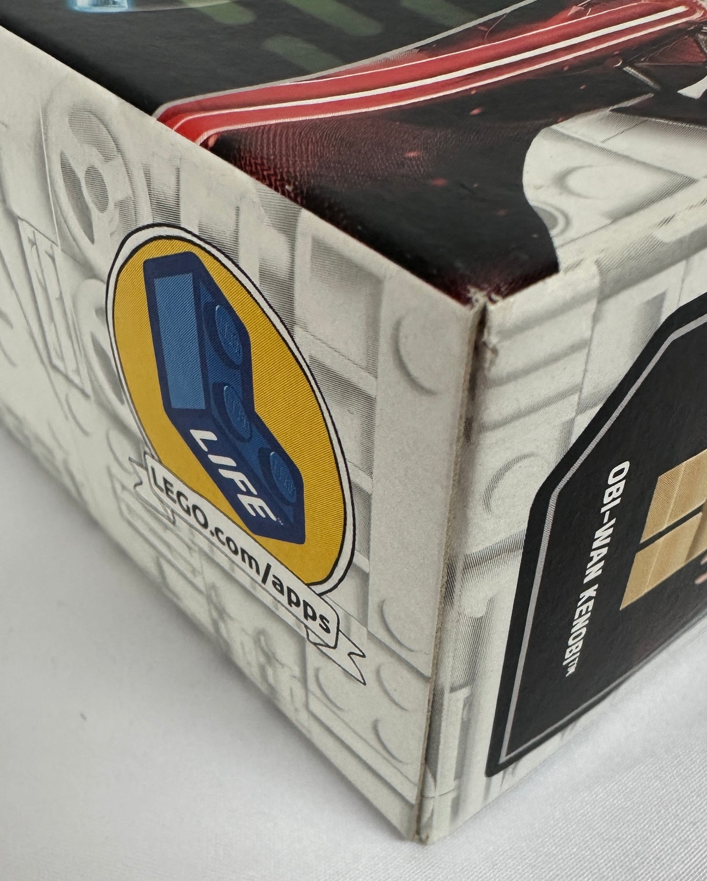 Close-up of a LEGO product packaging with branding and website information.