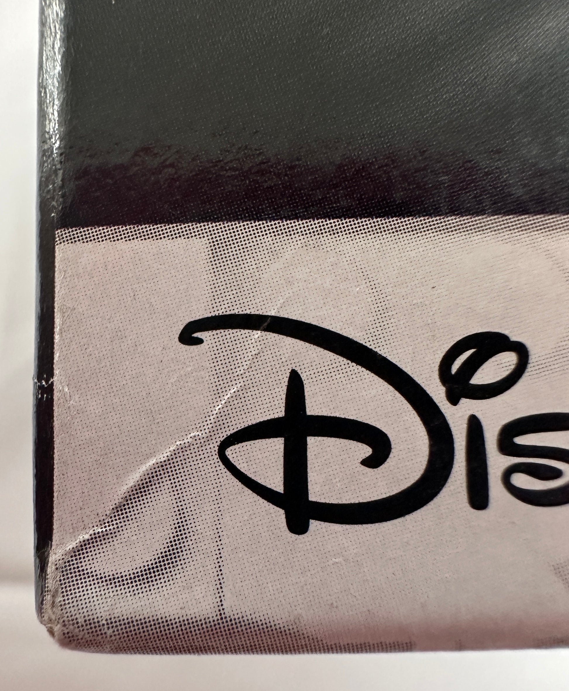 Close-up of a Disney logo on a product packaging with a black and gray design.
