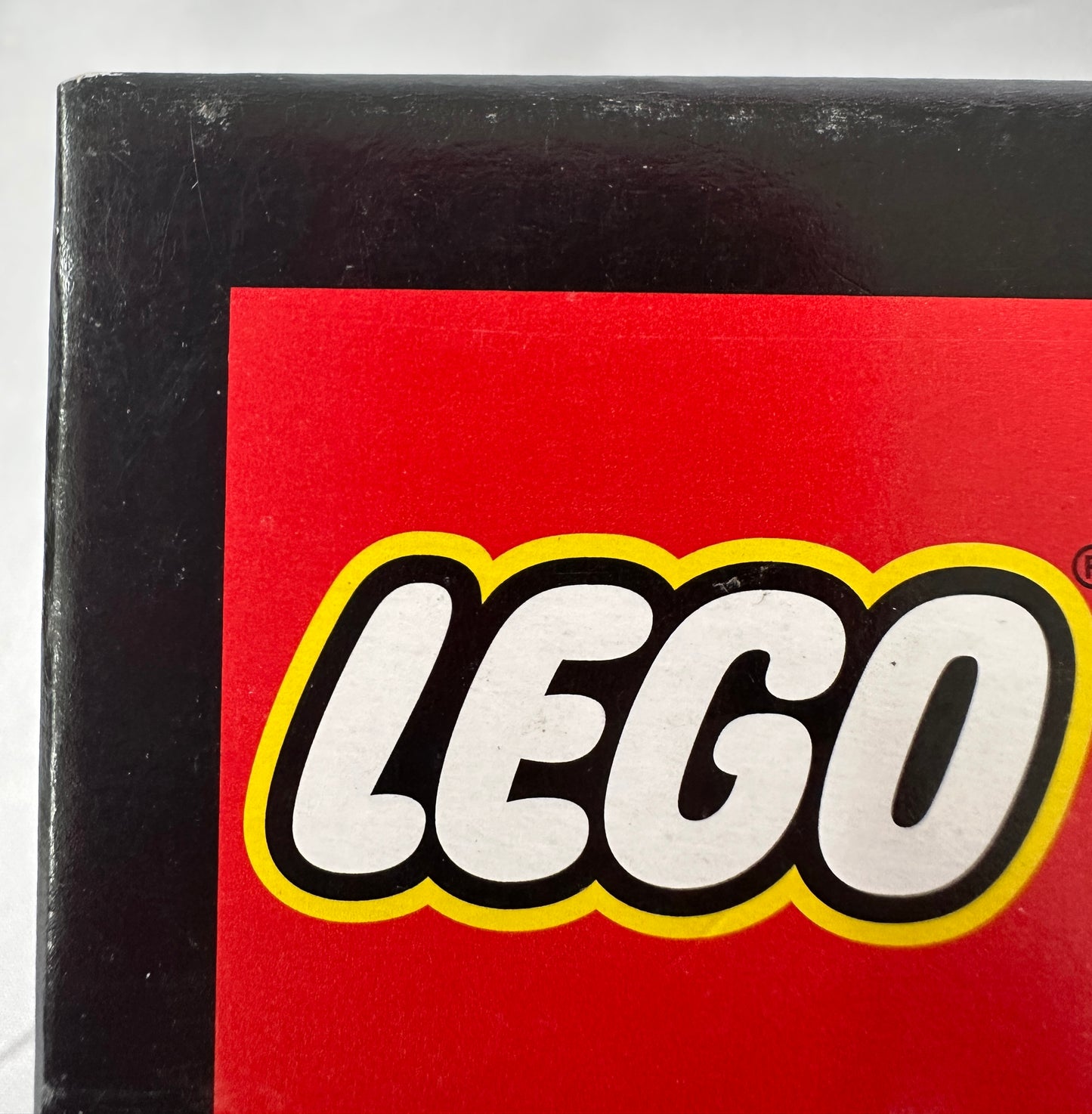 Close-up of a LEGO logo on a red and black box.