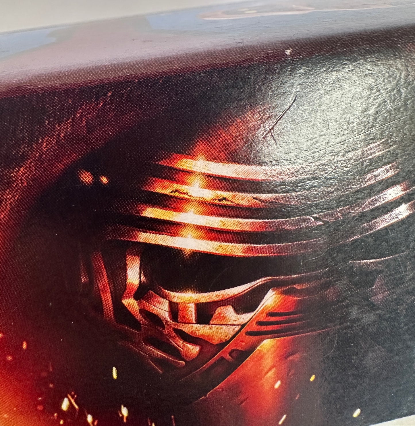 Close-up of a helmet with a glowing orange visor on a dark background