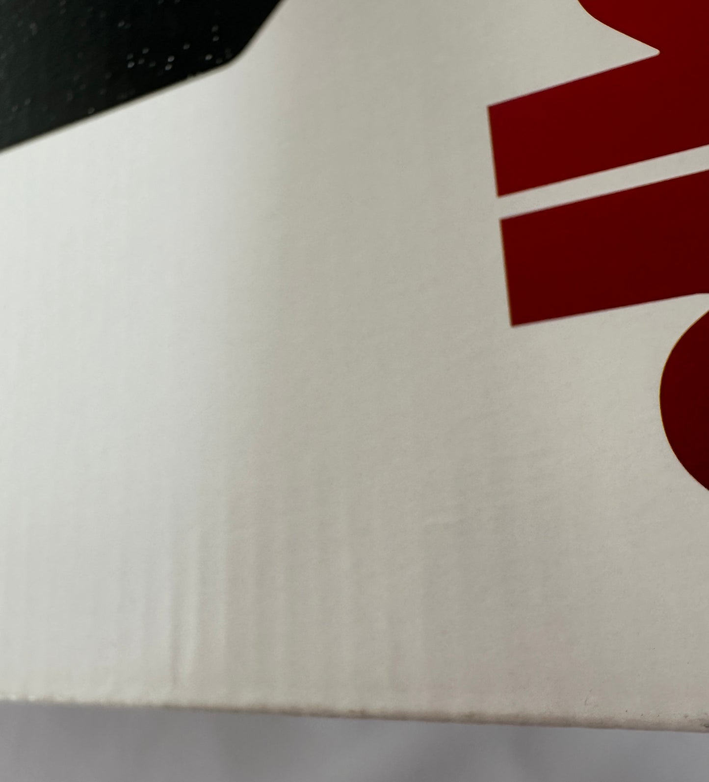Close-up of a white surface with a red logo on a black background