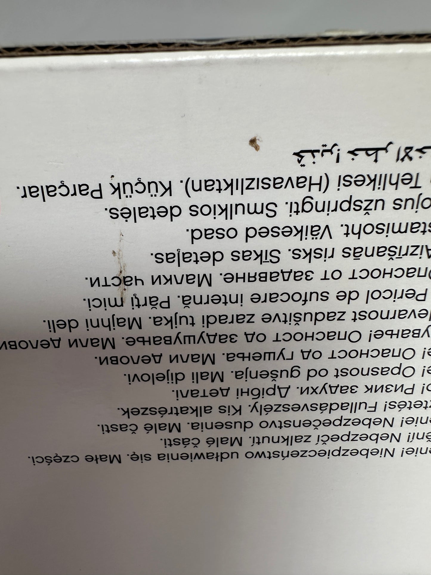 Close-up of a product label with text in multiple languages on a white background.