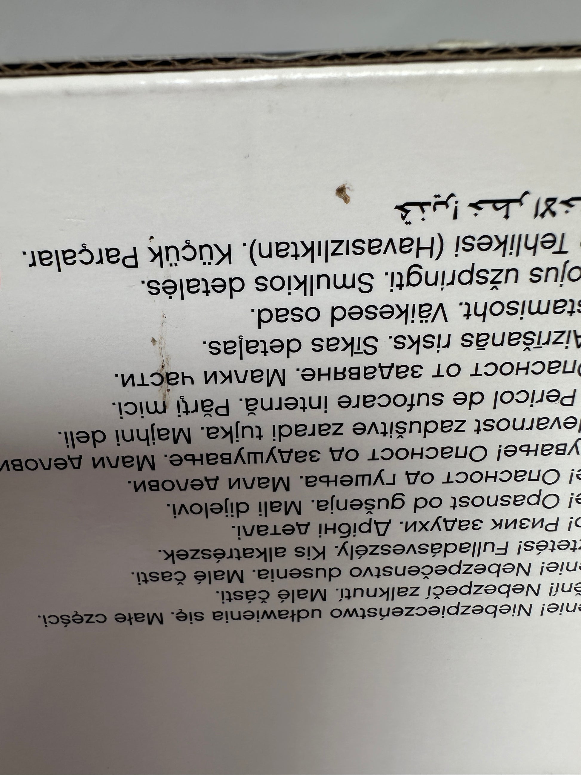 Close-up of a product label with text in multiple languages on a white background.