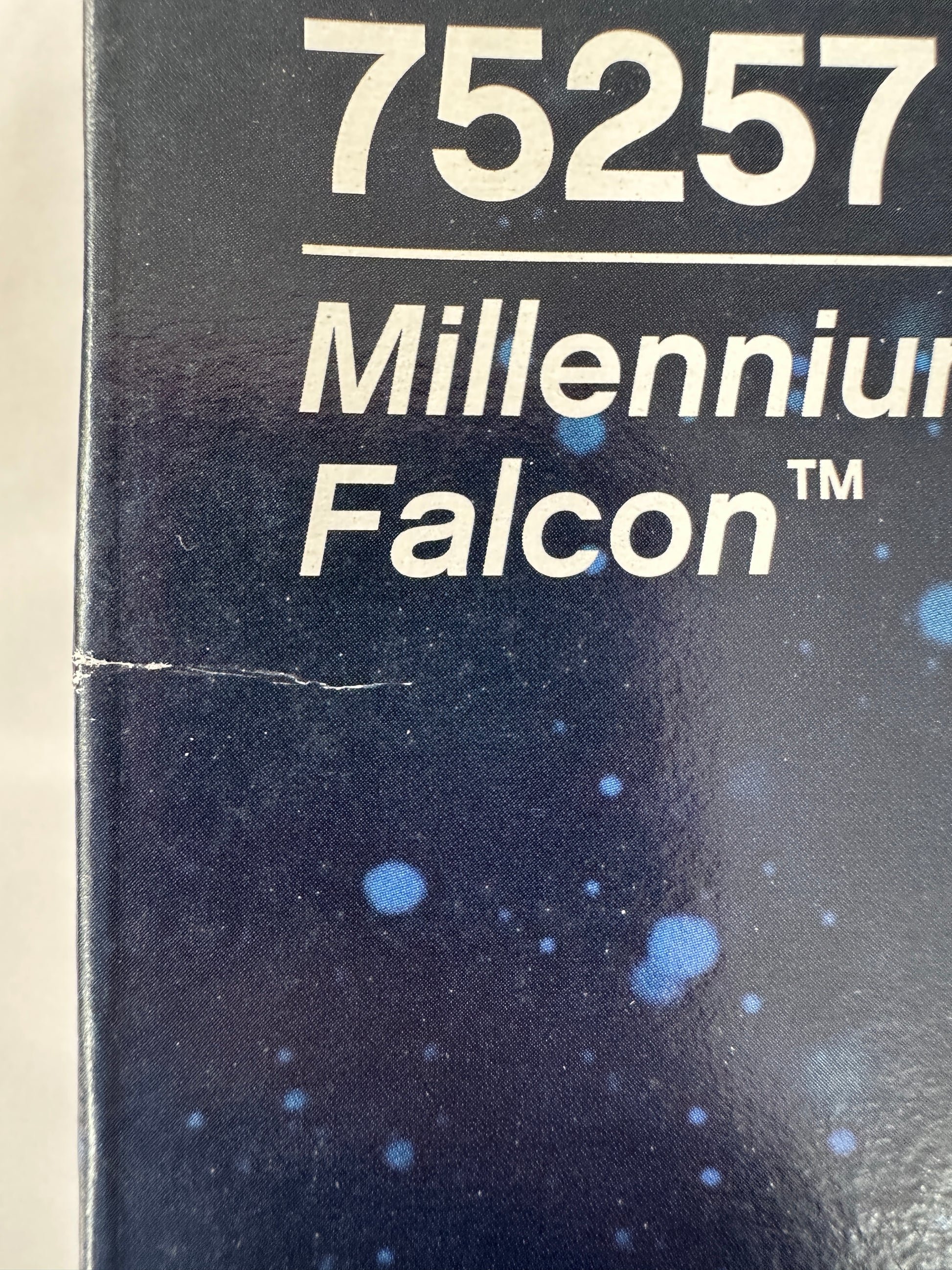 Text '75257 Millennium Falcon' on a dark background with star-like dots.