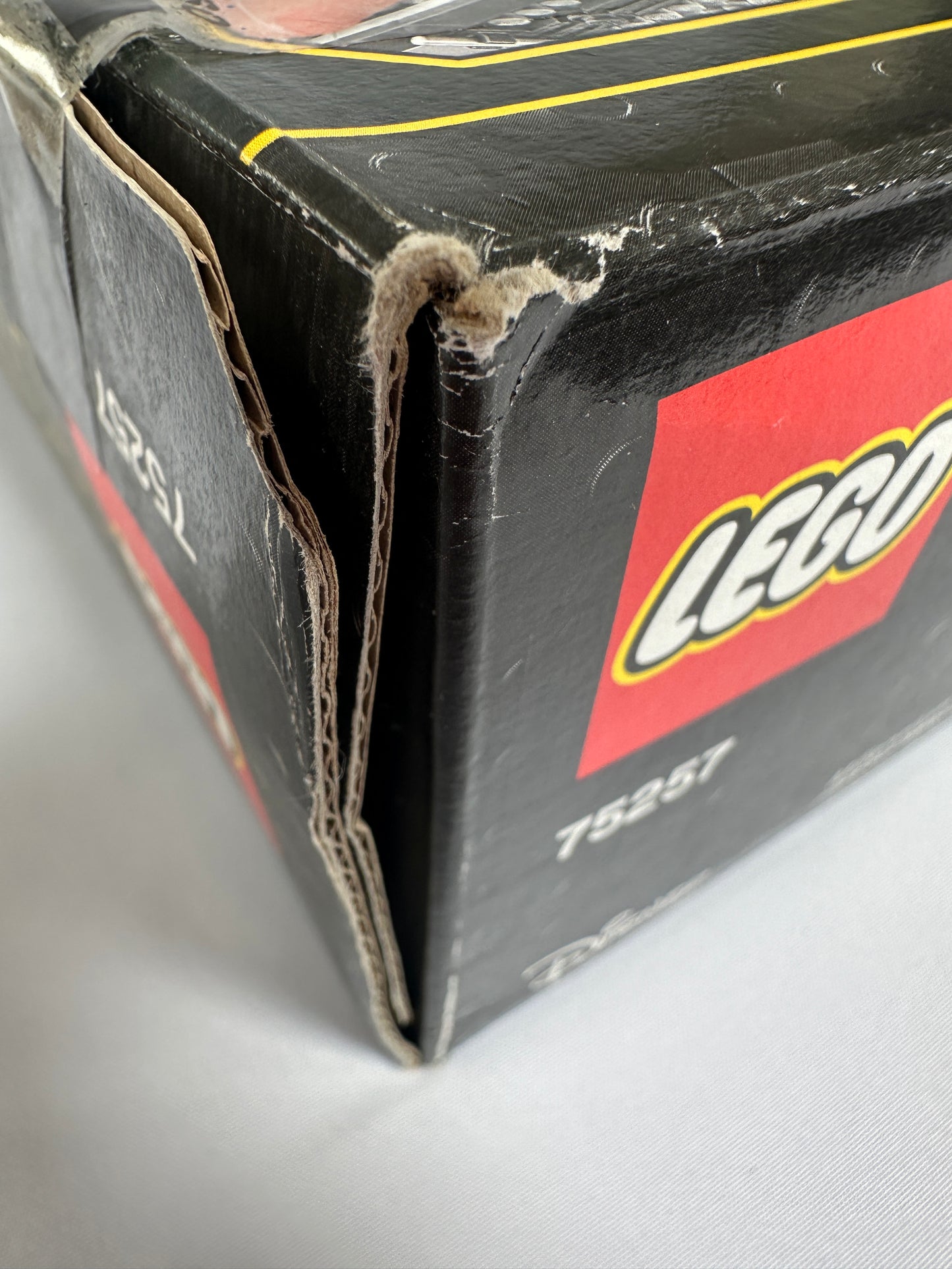 Close-up of a damaged LEGO box with visible wear and tear.