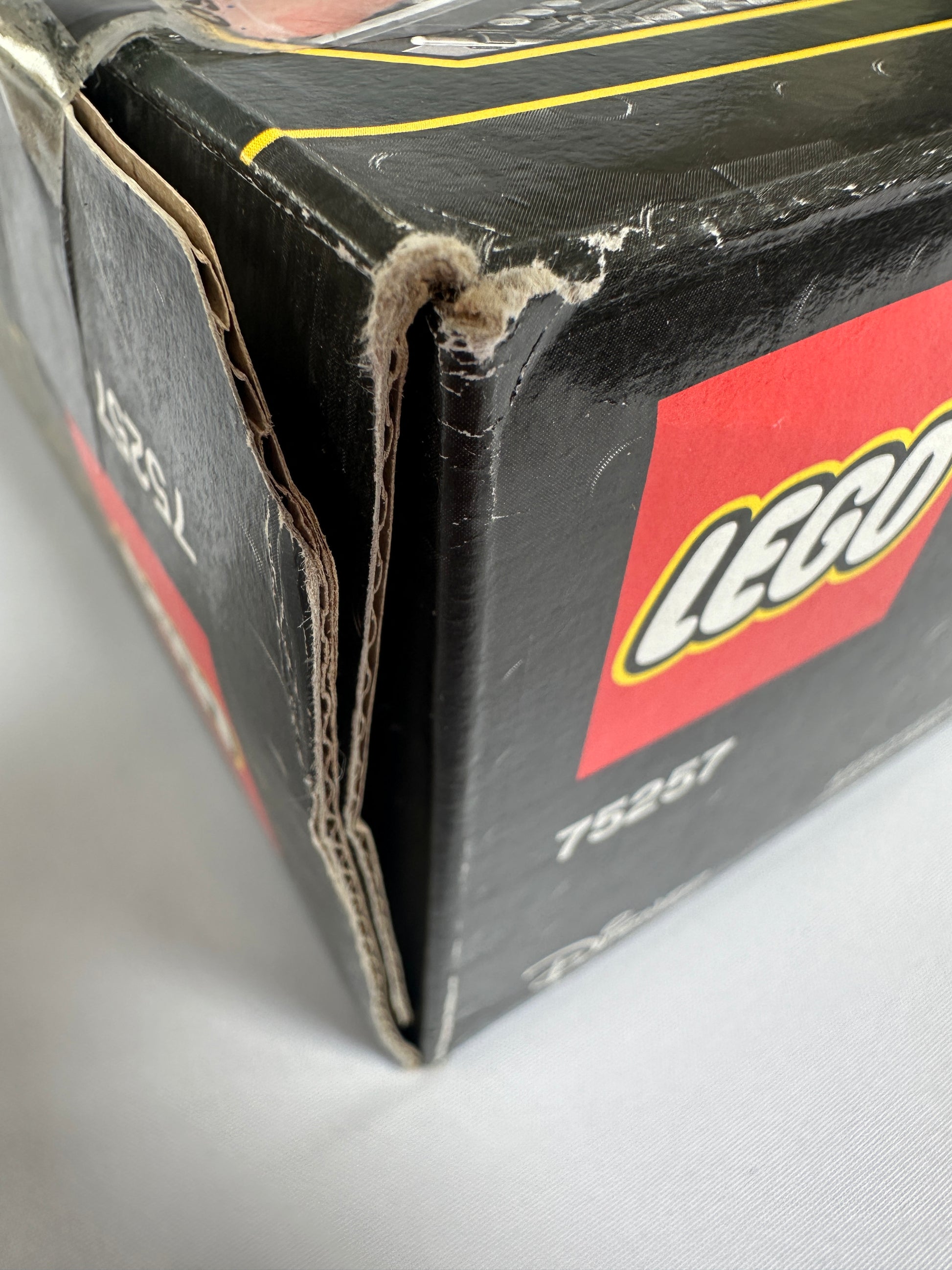 Close-up of a damaged LEGO box with visible wear and tear.
